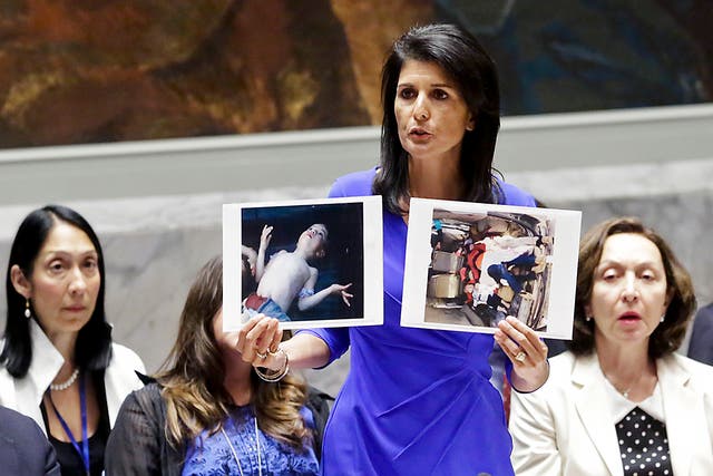 US Ambassador to the UN Nikki Haley holds up pictures showing alleged victims of a chemical gas attack in Syria's rebel-held Idlib province