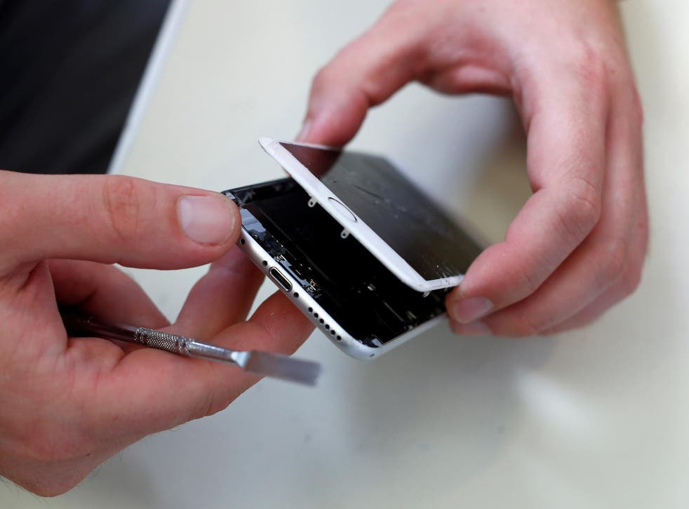 A technician opens a broken iPhone 6 by Apple in a shop in Fuerstenfeldbruck near Munich, Germany
