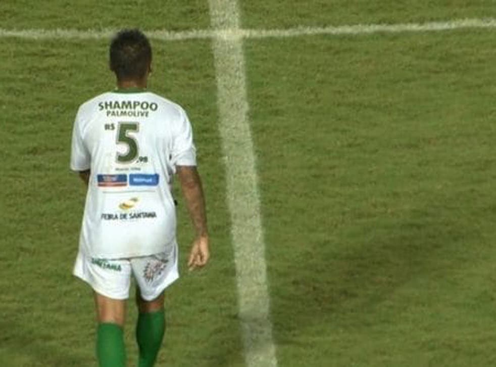 A Fluminense player displaying the price of a bottle of shampoo