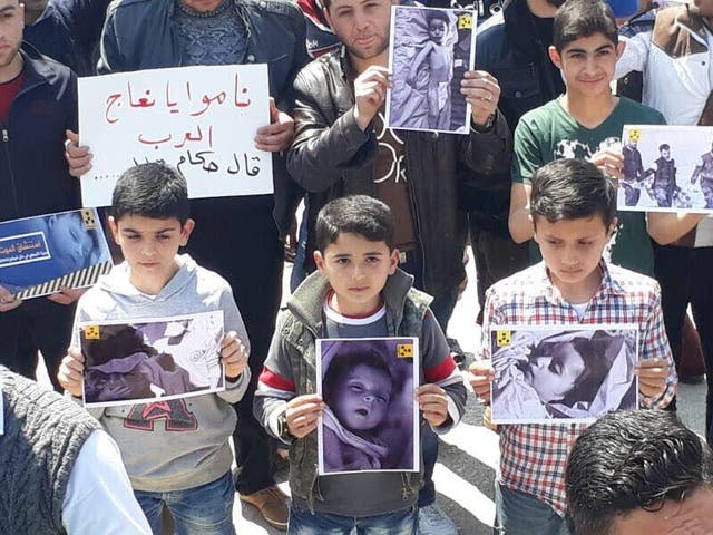 Children in Khan Sheikhoun hold pictures of children killed in a chemical weapons attack earlier this week in a demonstration in support of US intervention in the Syrian conflict on Friday April 7, 2017