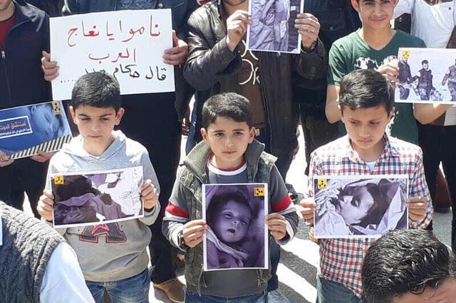 Children in Khan Sheikhoun hold pictures of children killed in a chemical weapons attack earlier this week in a demonstration in support of US intervention in the Syrian conflict on Friday April 7, 2017