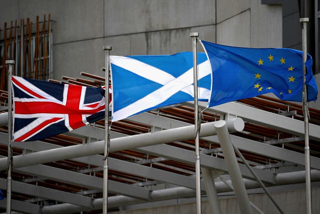 A Saltire, Union Jack and EU flags flutter in the wind outside the Scottish Parliament