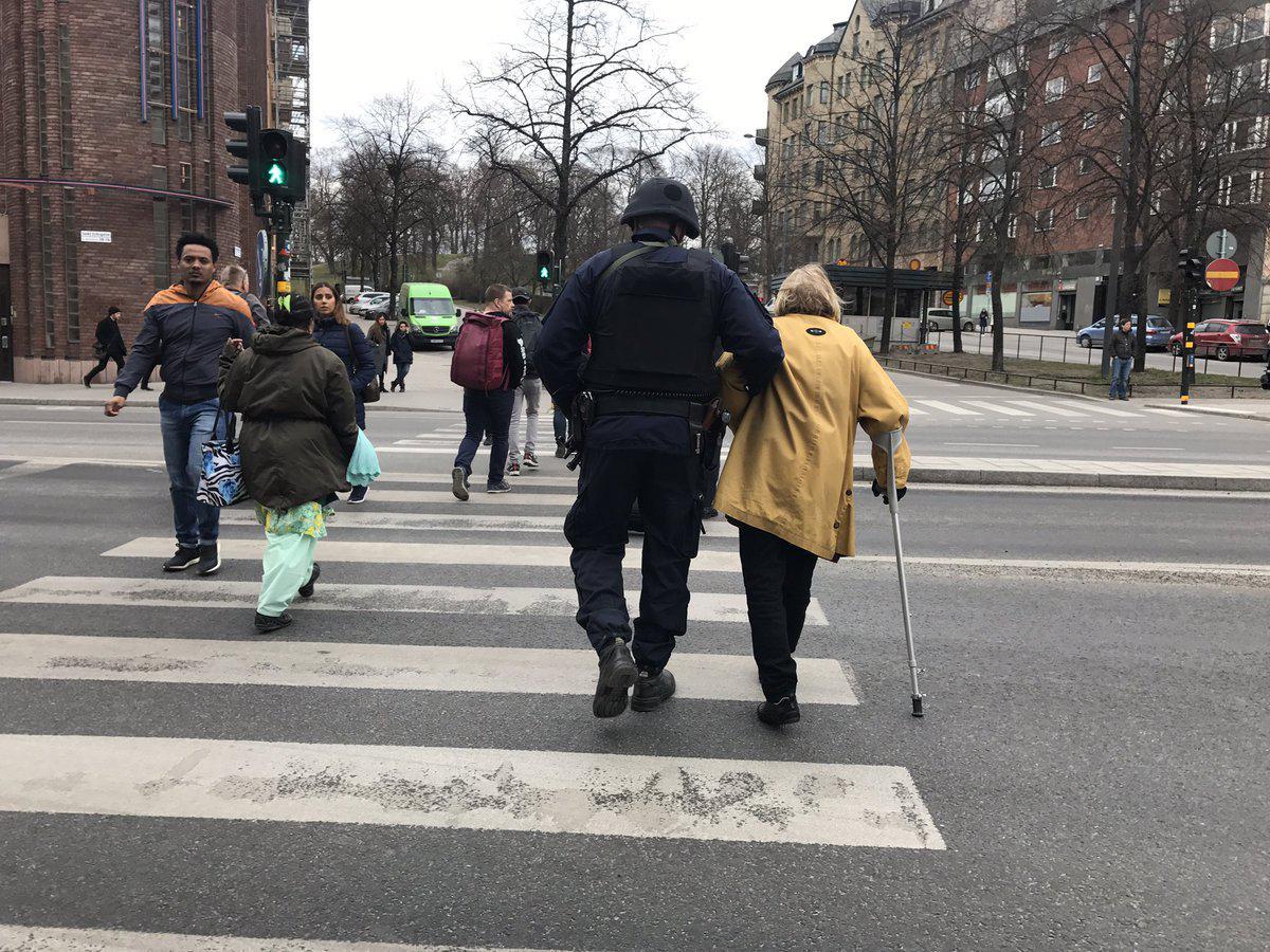 The image of the armed police officer leading an elderly lady across the road by the scene of the Stockholm attack has caught the imagination of Twitter