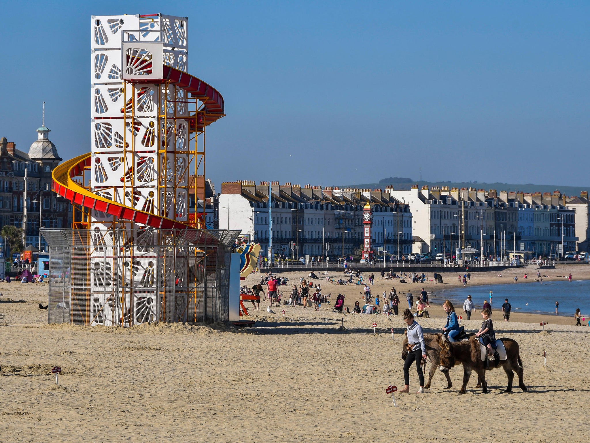 A bright idea: beachgoers in Dorset enjoy the balmy weather with suntanning and horseback rides