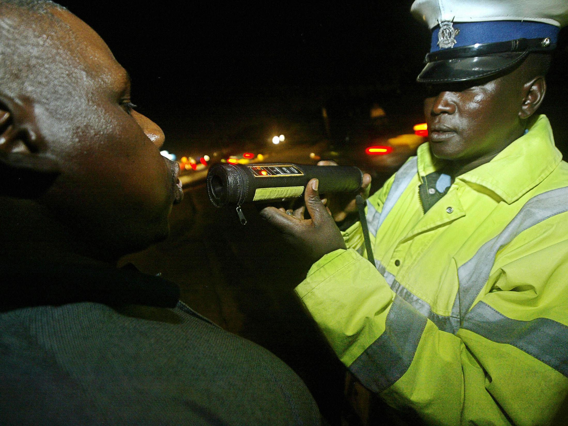 A Kenyan police officer administers a breathalyser test to a driver in Nairobi