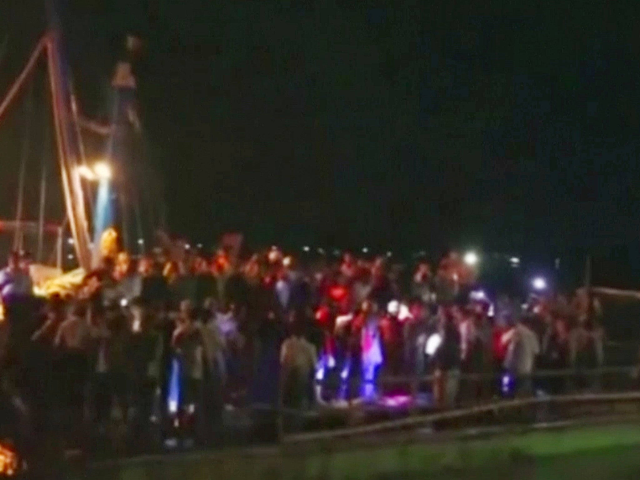 A crowd forms in Pathein, where survivors were taken to safety after being rescued