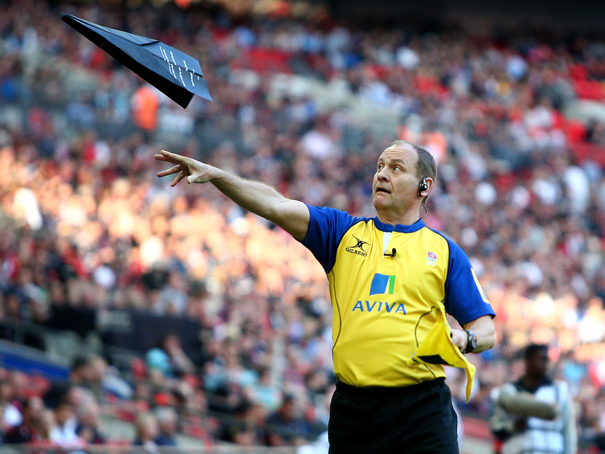 A line judge clears some litter