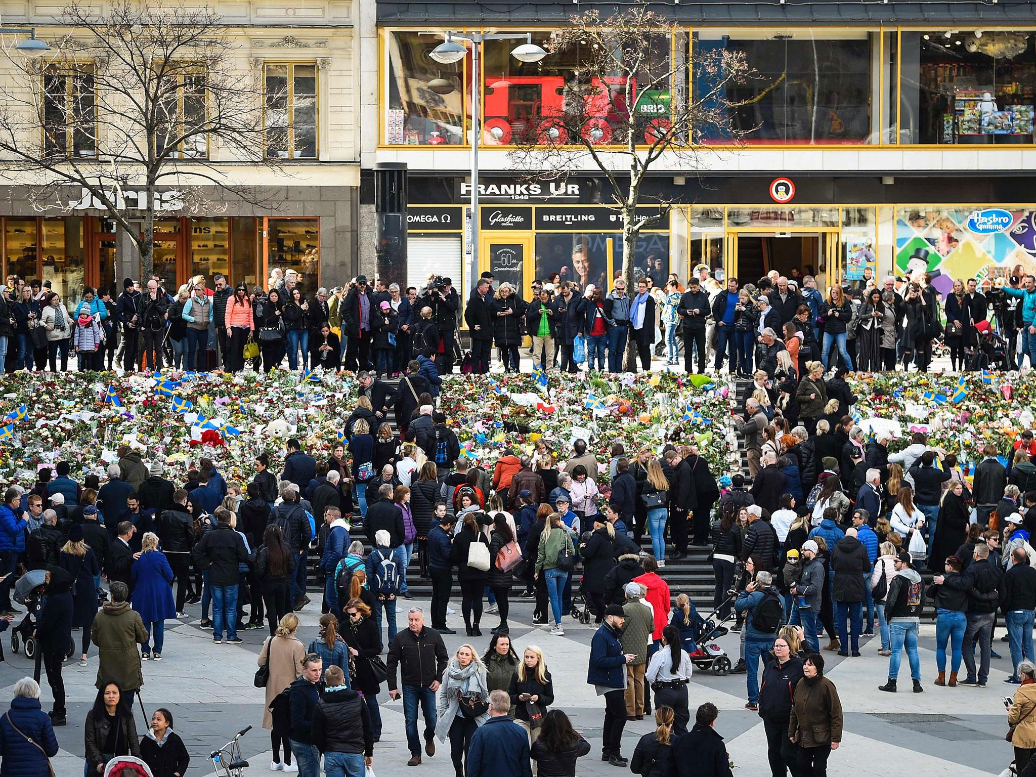 &#13;
People gather at a makeshift memorial near the point where a truck drove into a department store in Stockholm, killing four and injuring 15 (AFP/Getty)&#13;