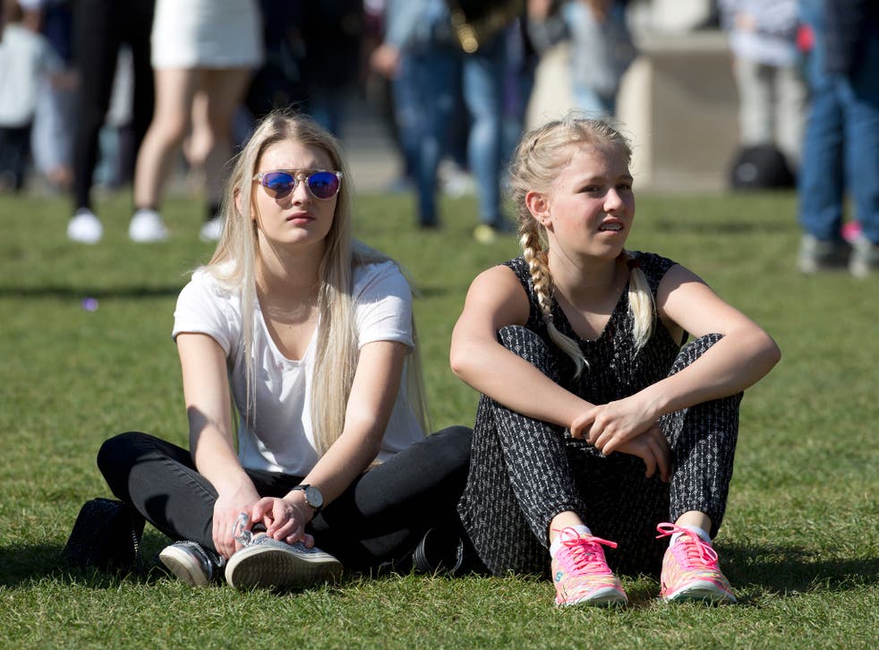 People enjoy the sunshine at Parliament Square in central London, on what is expected to be the hottest day of the year so far