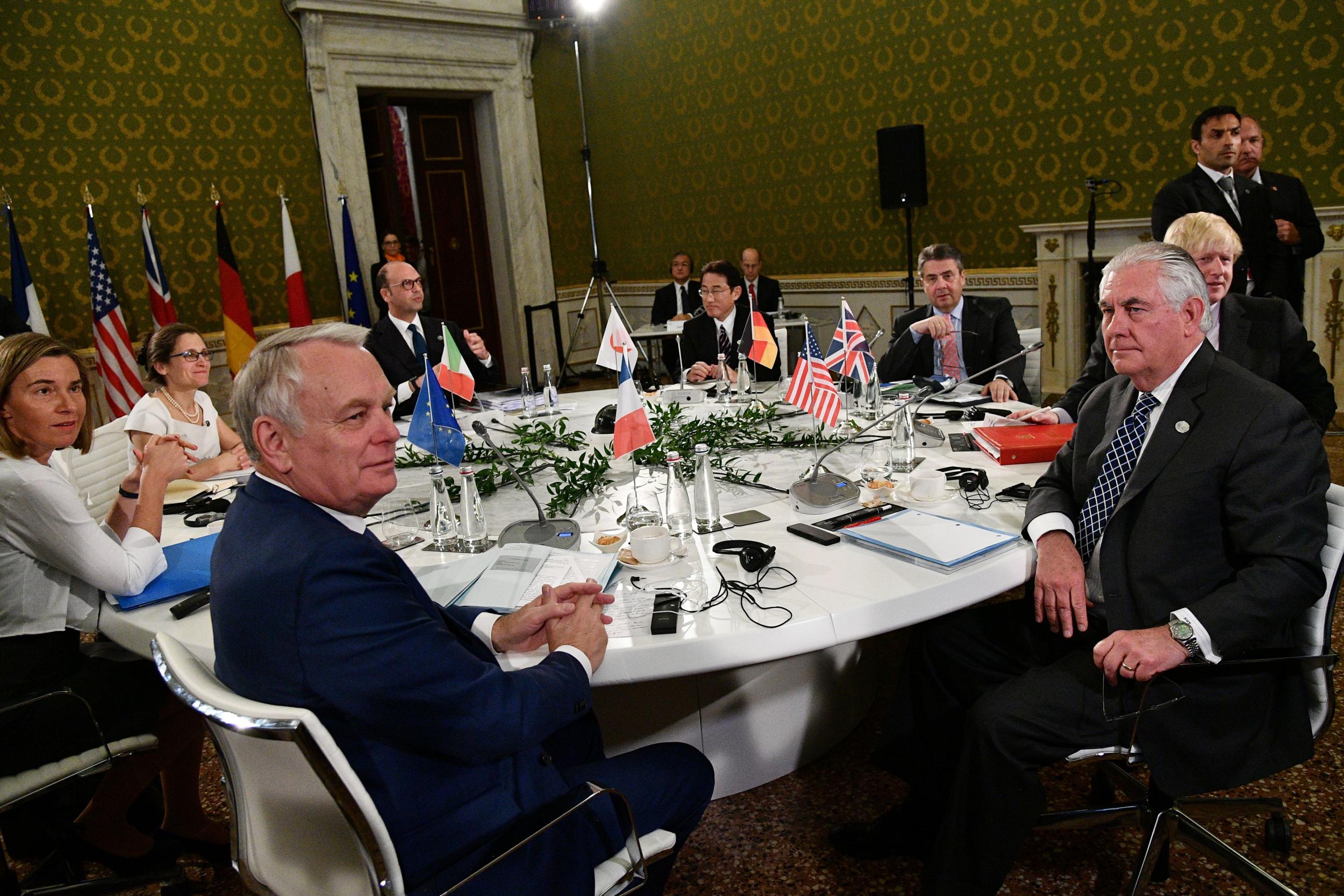 Foreign ministers from the G7 sit at a table on the second day of a meeting in Italy
