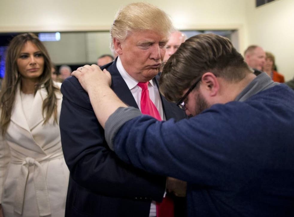Pastor Joshua Nink, right, prays for Republican presidential candidate Donald Trump, as his wife, Melania, watches after a Sunday service at First Christian Church, in Council Bluffs, Iowa, in January 2016