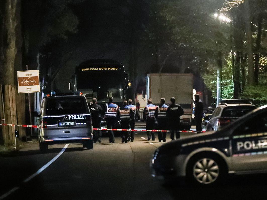 Investigators examine the Borussia Dortmund team bus, which was damaged in a bomb attack