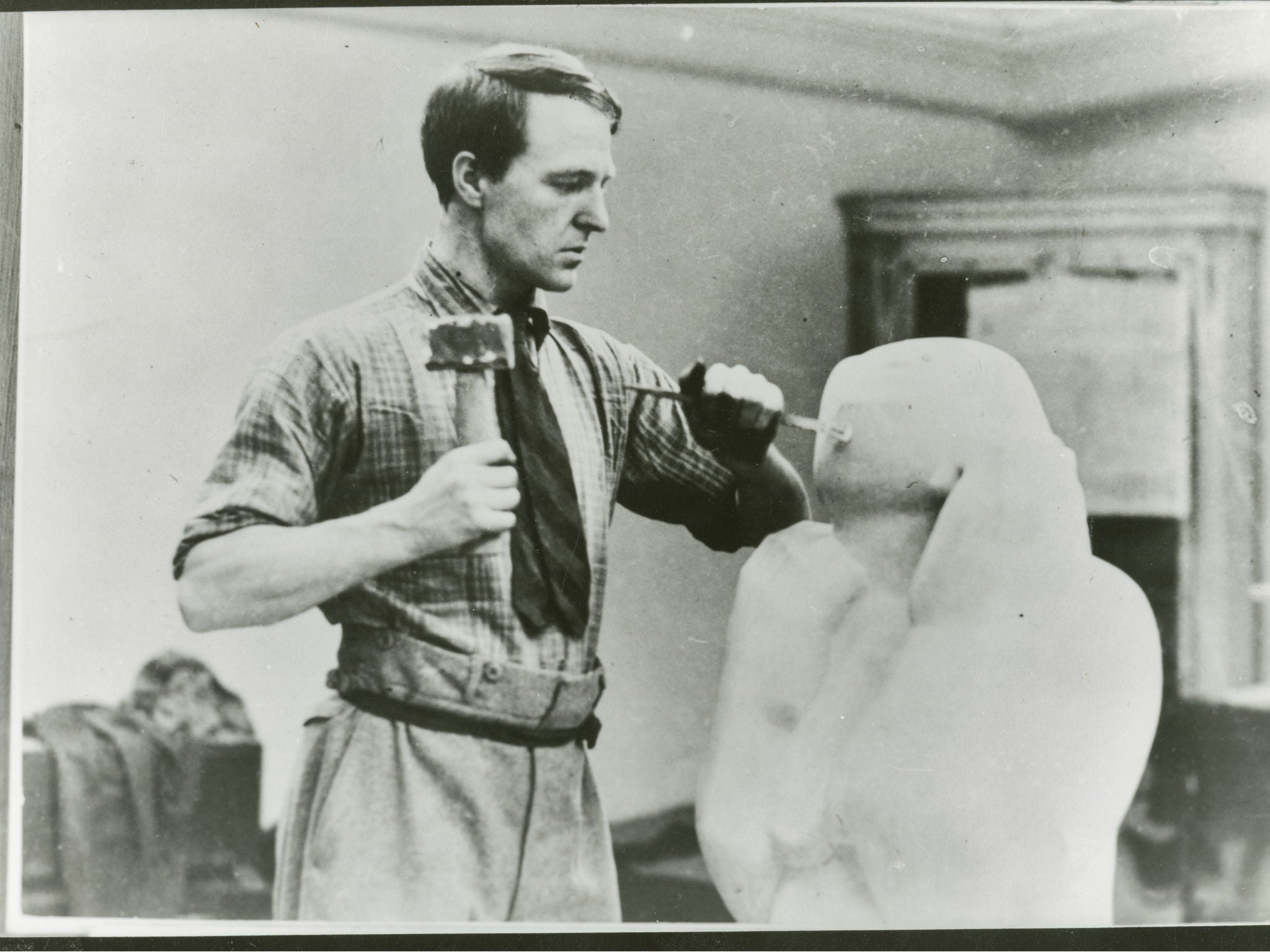 Henry Moore carving a stone work at 3 Grove Studios, Adie Road Hammersmith, London 1928