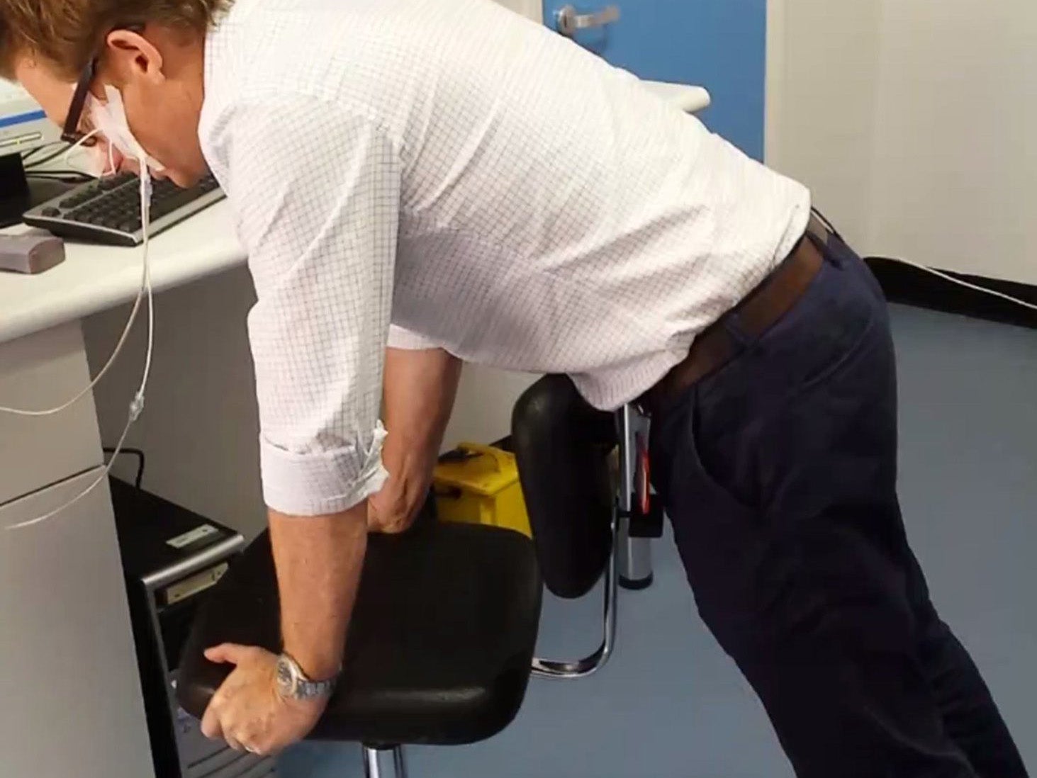 A researcher demonstrates how to perform 'chair thrusts'