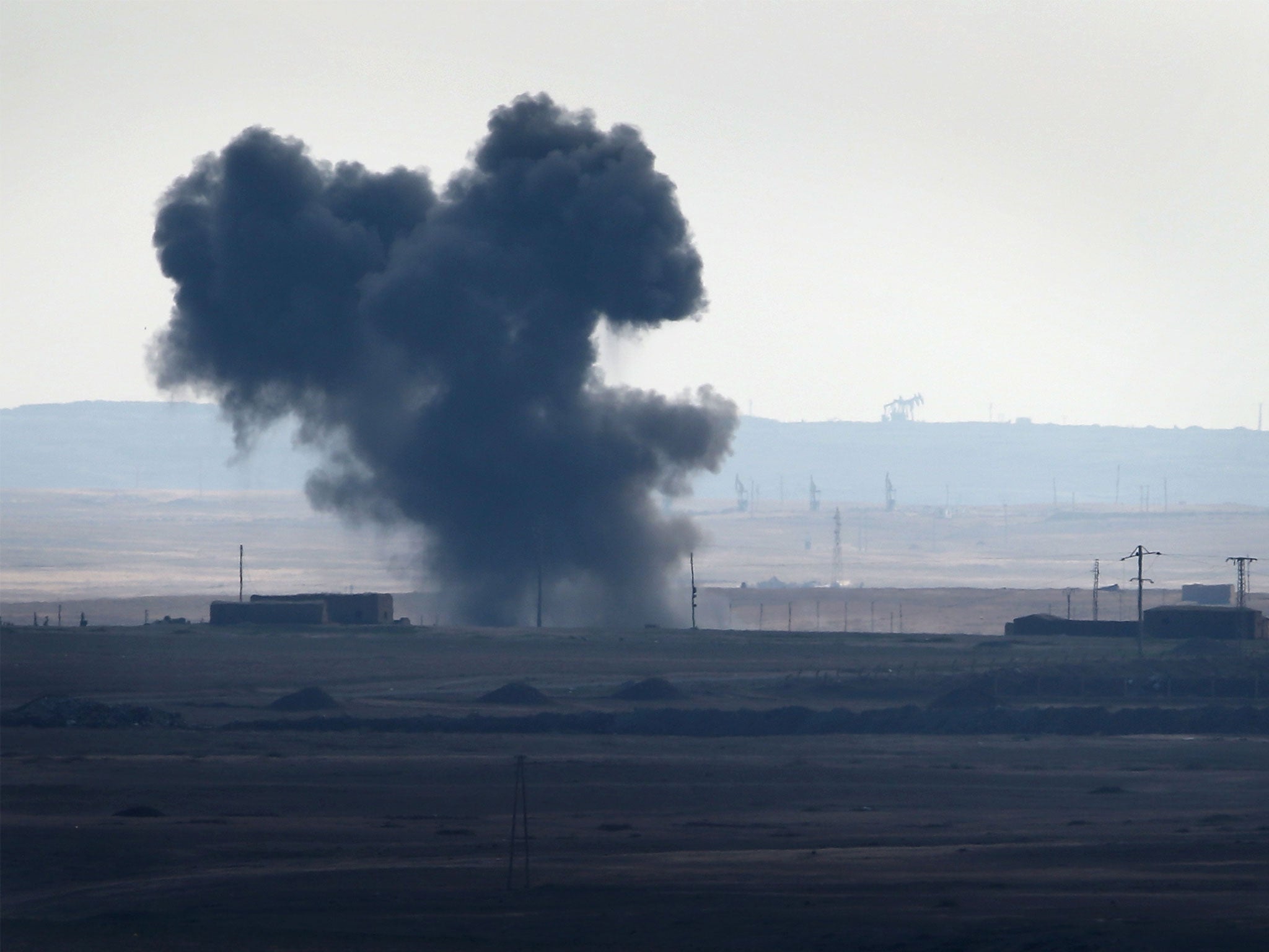 An air strike by a US-led coalition warplane explodes on an Isis position on November 10, 2015 near the town of Hole, Rojava, Syria