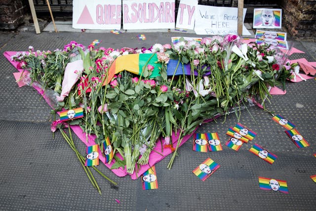Flowers and pink triangles like those fixed to queer people in Nazi concentration camps were laid at the embassy gates