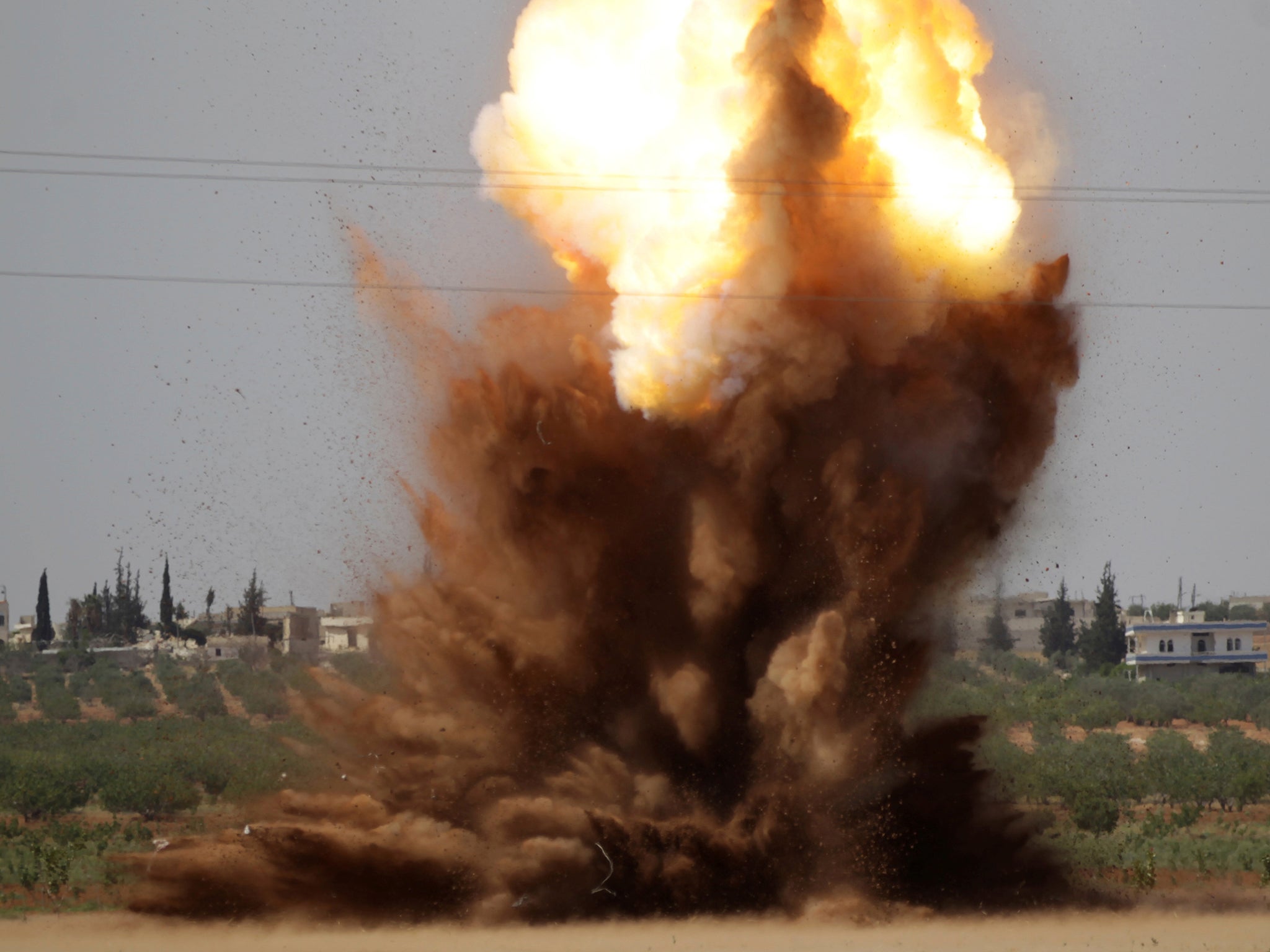 Smoke rises after civil defence members safely detonate cluster bombs inside a field in al-Tmanah town in southern Idlib countryside, Syria