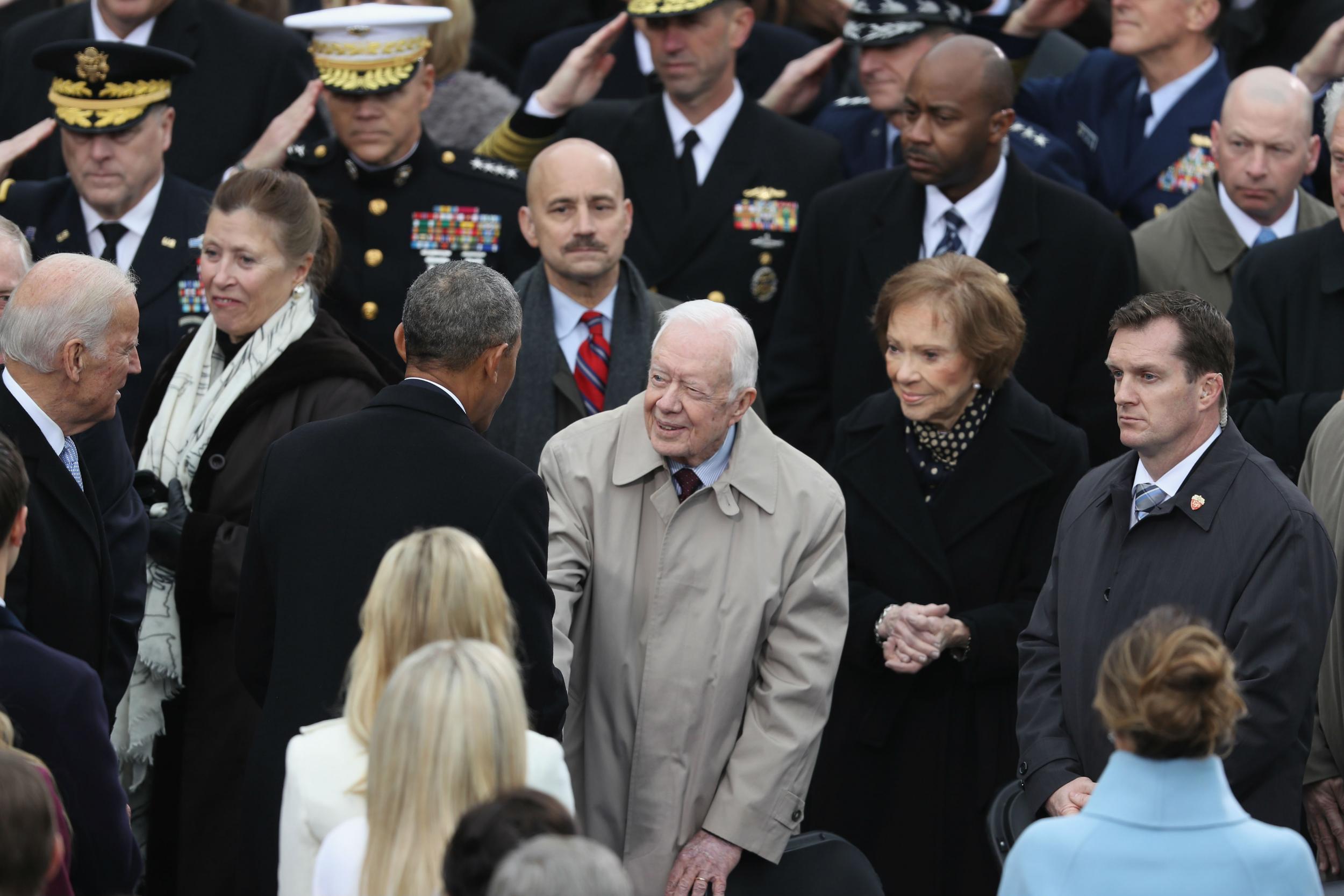 Former President Jimmy Carter being greeted by Barack Obama at the Trump inauguration this January