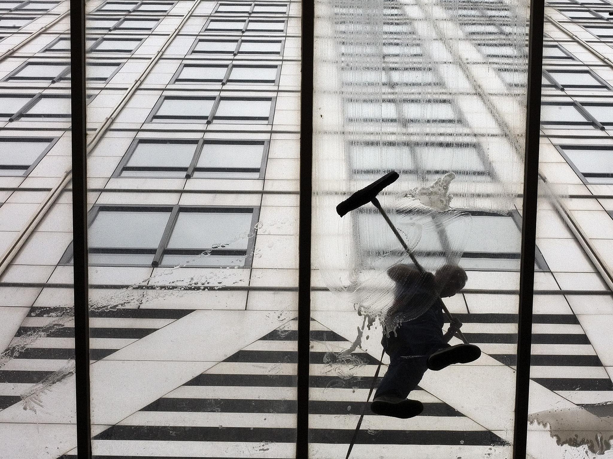 Workmen wash the entrance of 1 Canada Square in London's Canary Wharf, where the European Banking Authority is based - for now
