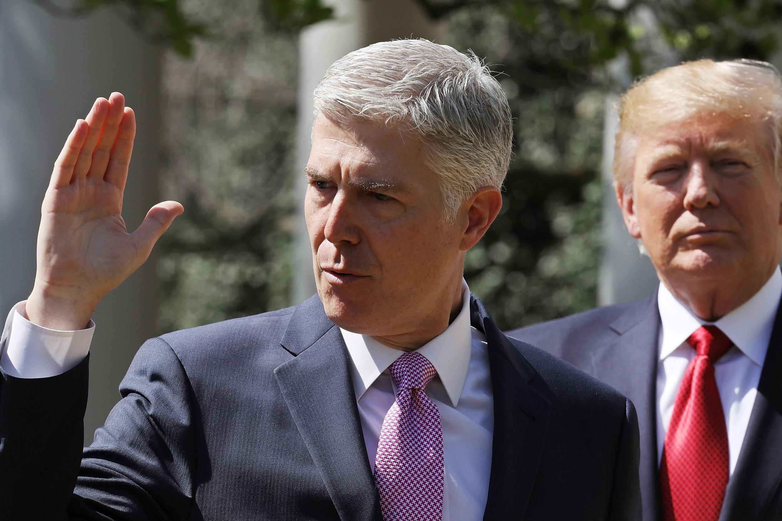 U.S. Supreme Court Associate Justice Judge Neil Gorsuch takes the judicial oath as President Donald Trump looks on