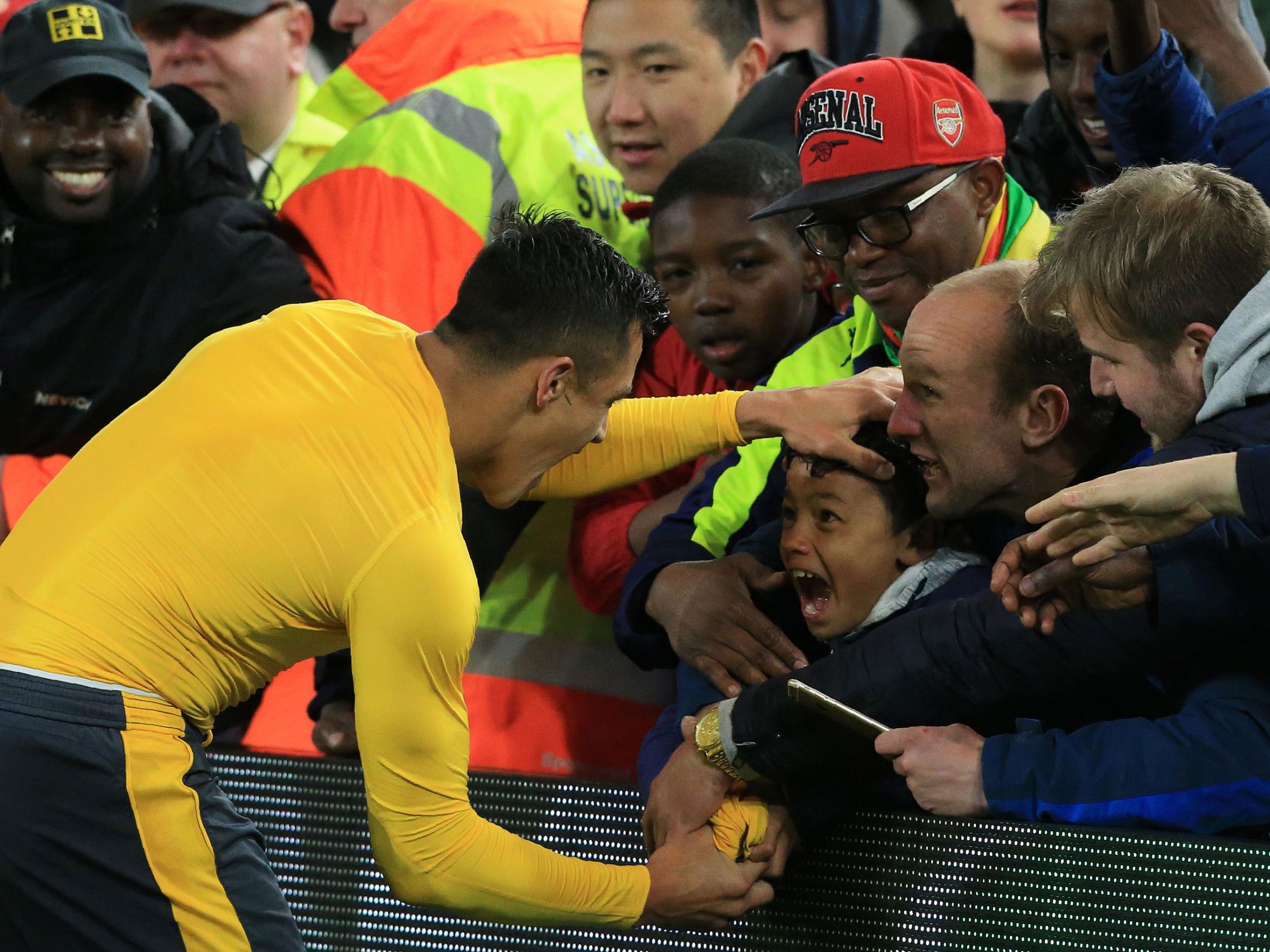 Alexis Sanchez gives his shirt to a fan after the win at Boro