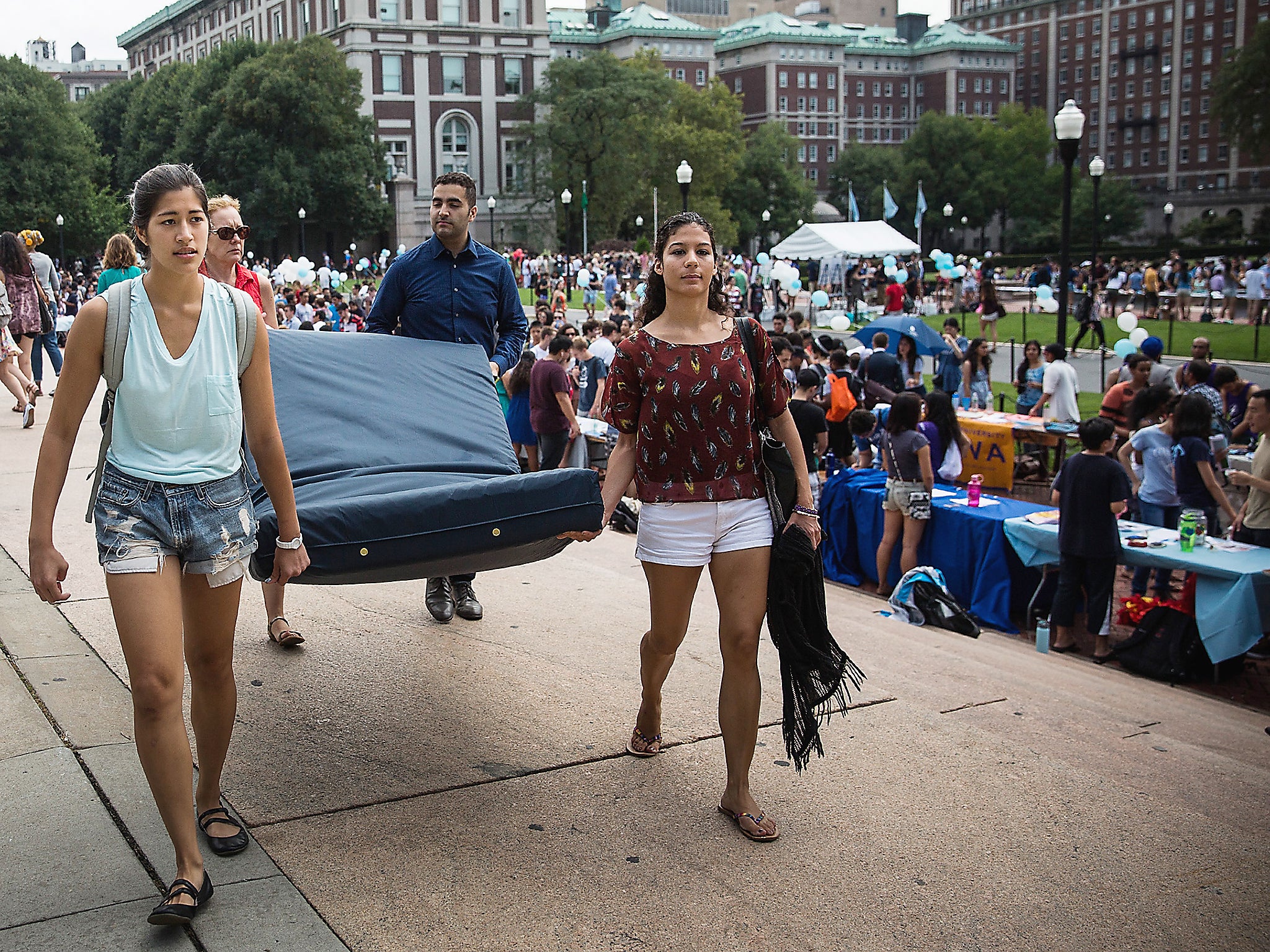 Emma Sulkowicz (left), a student at Columbia University, carries a mattress in protest of the university’s lack of action after she reported being raped (Getty)