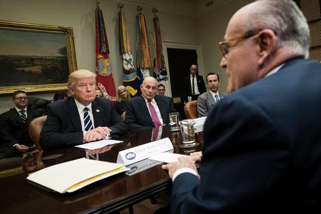 Donald Trump, Secretary of Homeland Security John Kelly, Reed Cordish, Director of Government Initiatives, and others listen while former New York Mayor Rudy Giuliani speaks during a meeting on cyber security