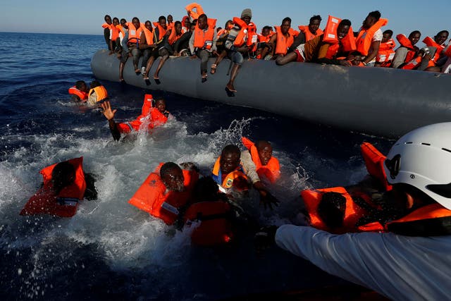 Migrants try to stay afloat after falling off their rubber dinghy during a rescue operation by Moas off the coast of Zawiya in Libya