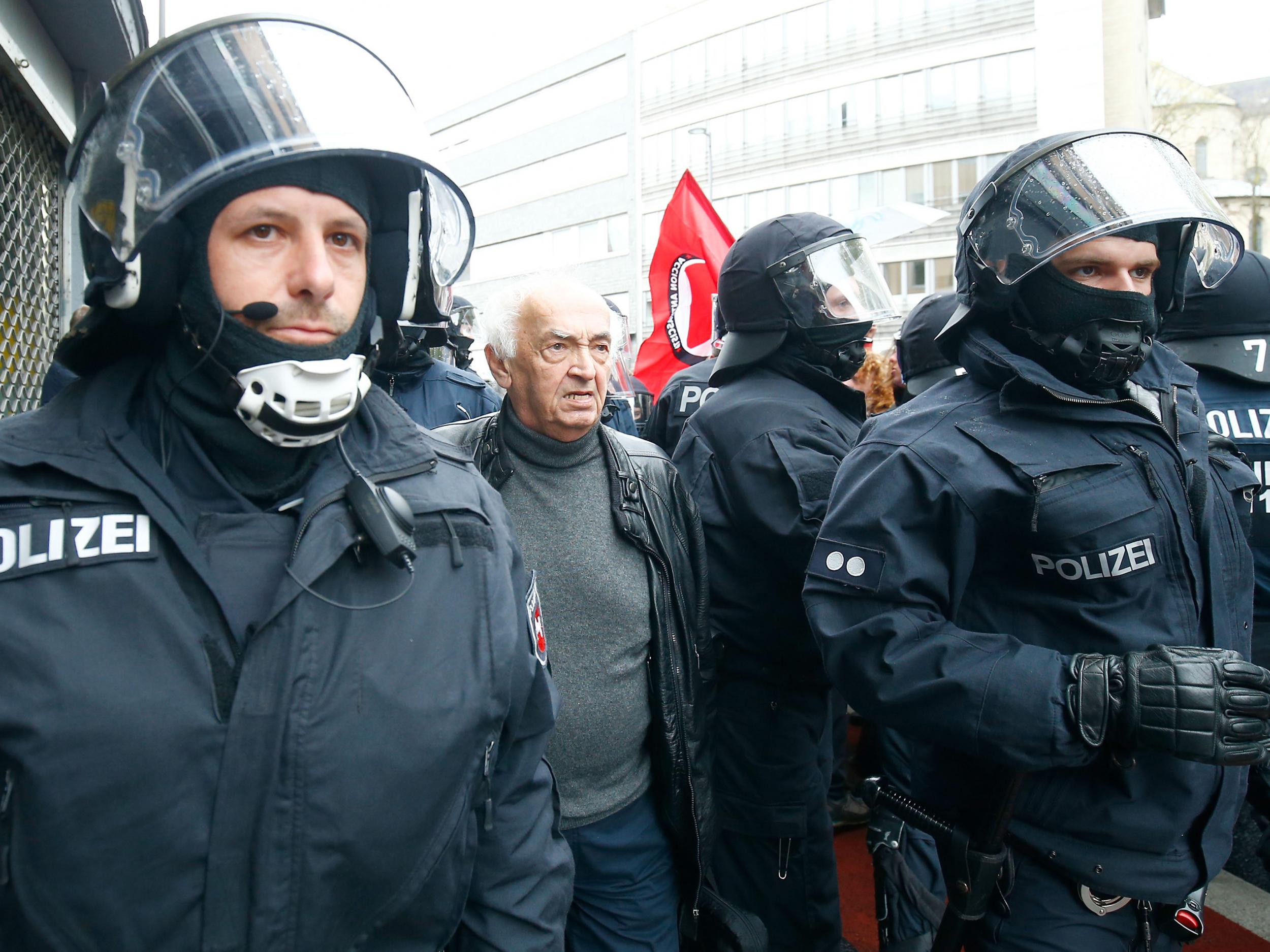 Police escort an AfD delegate to the venue of the anti-immigration party's conference in Cologne