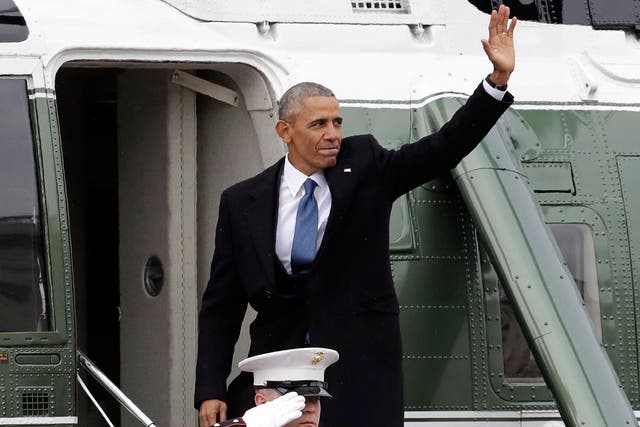 Former President Barack Obama waves as he boards a Marine helicopter