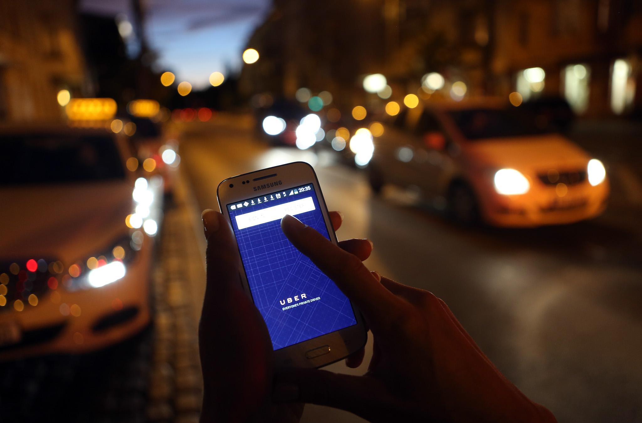 In this photo illustration, a woman uses the Uber app on an Samsung smartphone on September 2, 2014 in Berlin, Germany