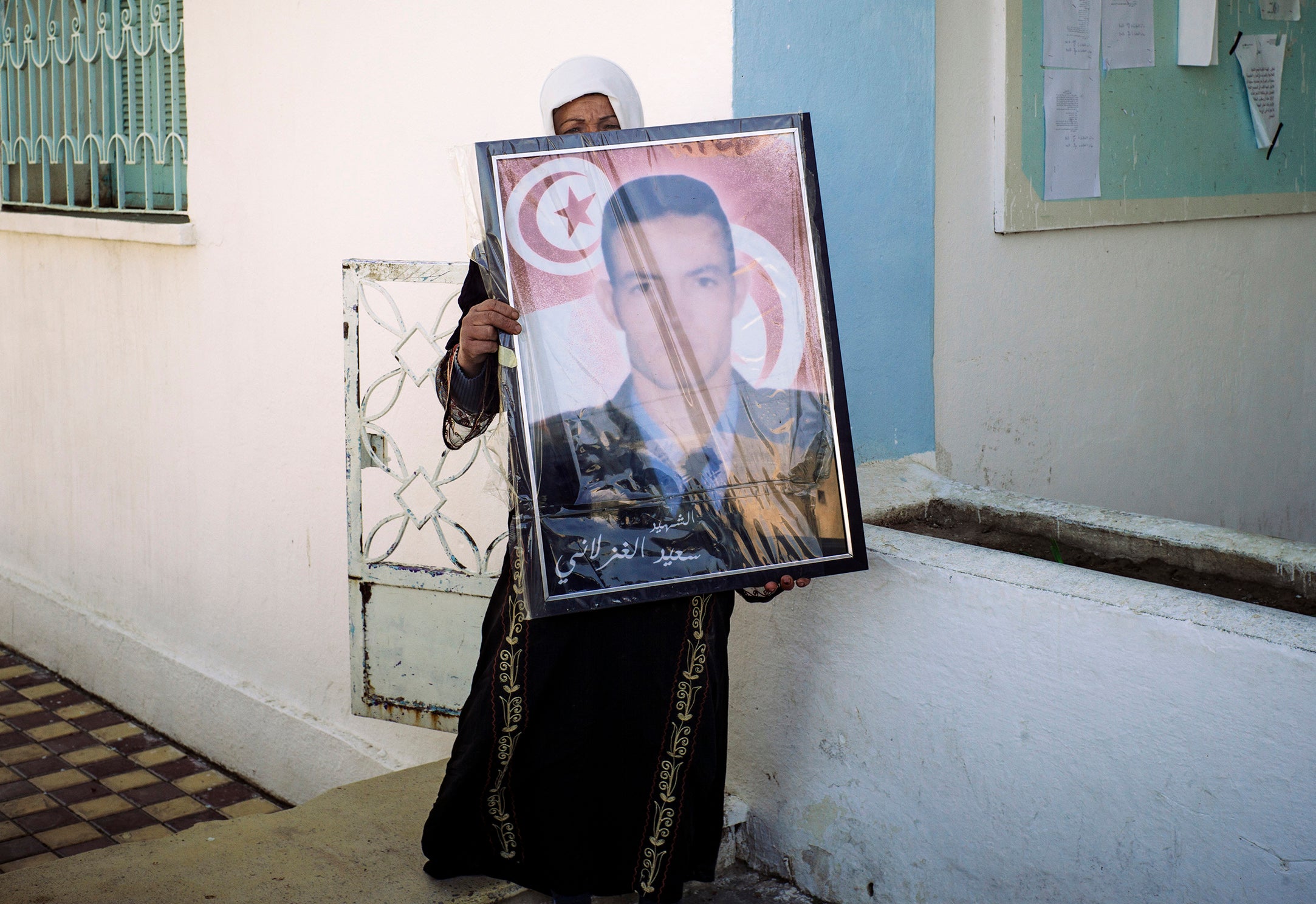 Fadha Ghozlani shows a portrait of her brother Sayed, who was murdered by Isis militants in the family home. Among Sayed's killers was a cousin