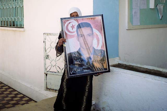 Fadha Ghozlani shows a portrait of her brother Sayed, who was murdered by Isis militants in the family home. Among Sayed's killers was a cousin