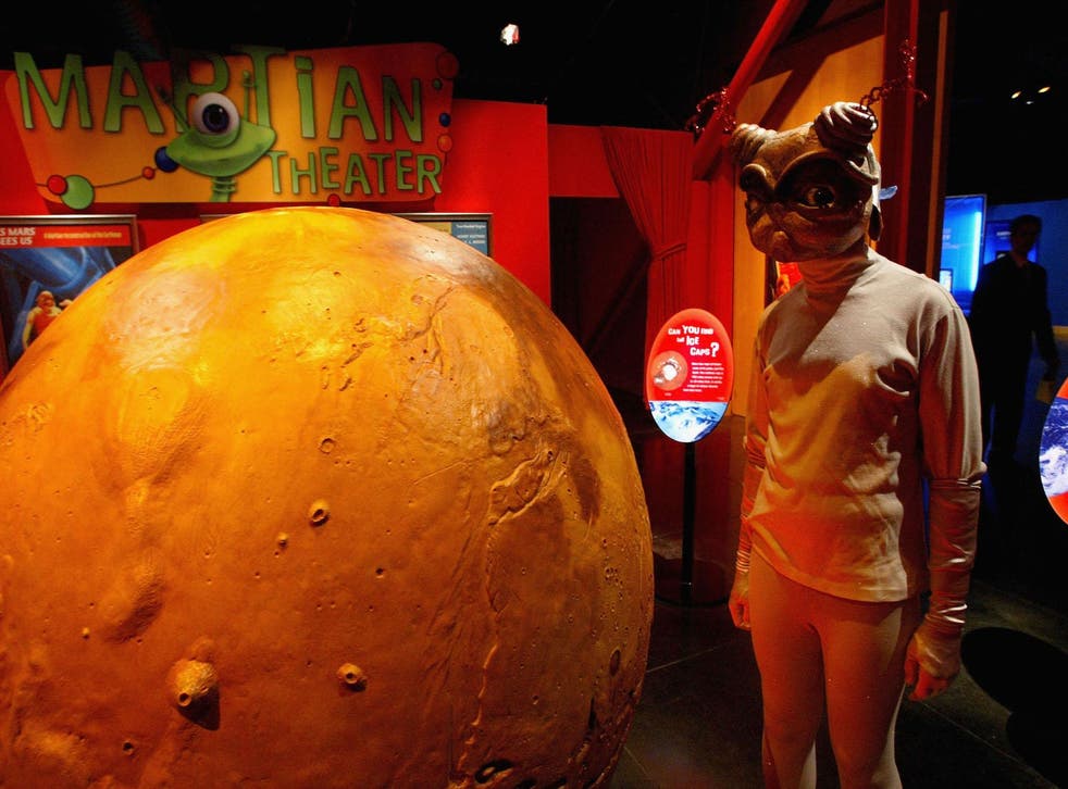 person dressed as an alien attends the Mars Encounter exhibit at the Chabot Space and Science Center August 26, 2003 in Oakland, California. Hundreds of astronomy enthusiasts visited the Chabot Space Center in hopes of viewing the red planet Mars through high-powered telescopes