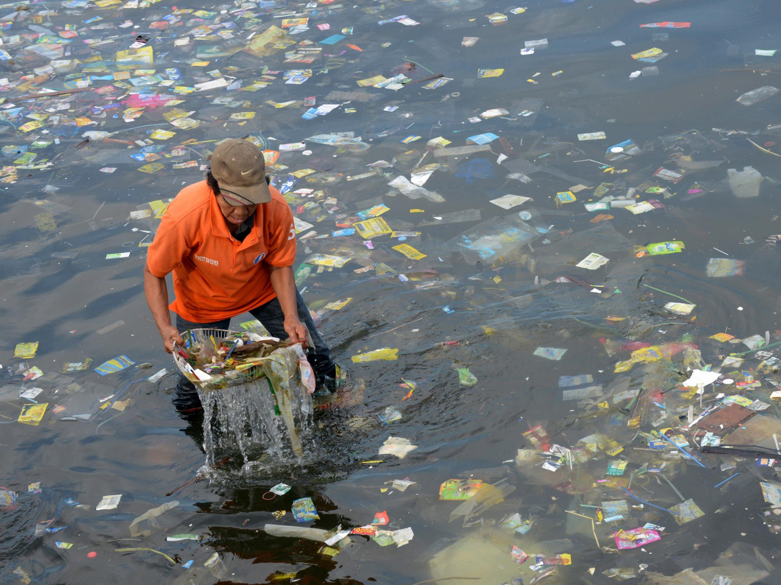 A worker cleaning up Manila Bay in the Philippines. Anywhere in the world, once plastic goes into the water it can be carried to the Arctic by ocean currents