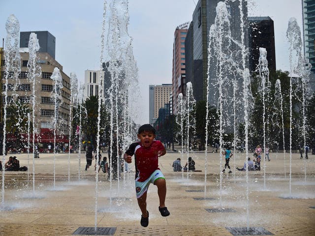 A boy plays in a fountain in Mexico City