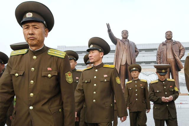 North Korean soldiers walk in front of bronze statues of Kim Il-sung and lKim Jong-il in Pyongyang to mark the 85th anniversary of the founding of the Korean People's Army on 25 April