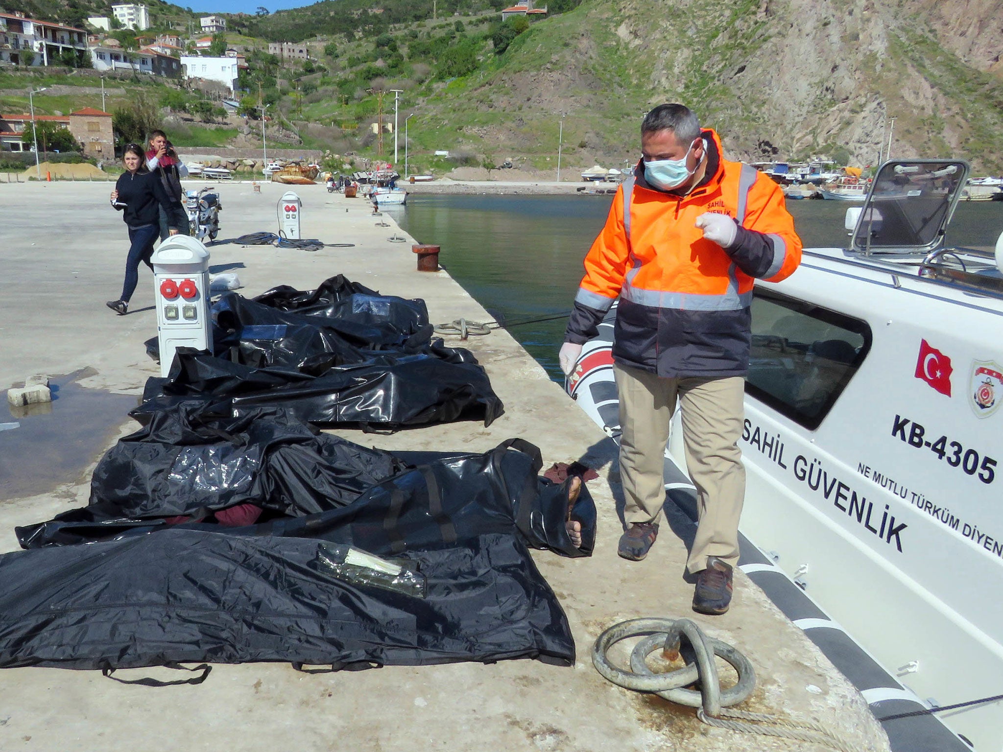 Turkish coastguard officers line up the bodies of migrants who drowned when their boat sank as they were trying to reach the nearby Greek island of Lesbos on 24 April