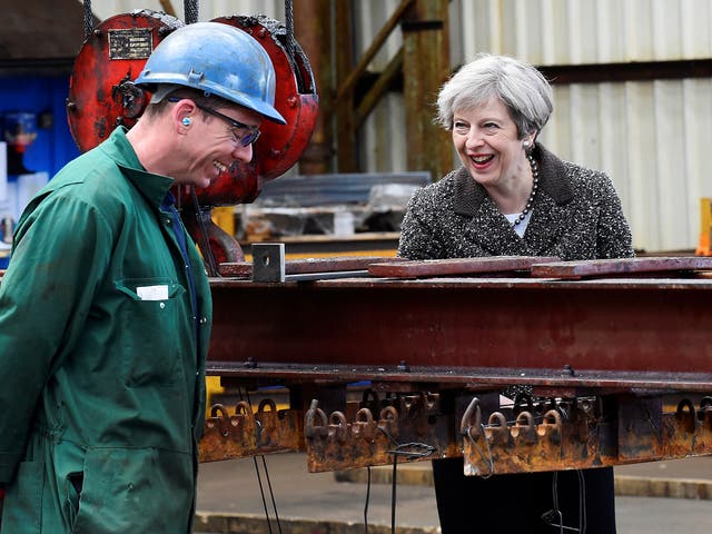 Prime Minister Theresa May speaks to a worker during a visit to a steel works in Newport, Wales