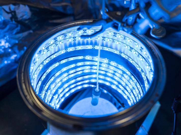 An artificial photosynthesis device glows blue like a tanning bed