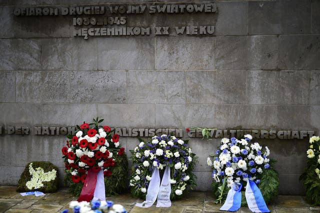 Wreaths are seen in front of a memorial plaque during a ceremony to commemorate the 70th anniversary of the liberation of the Bergen-Belsen concentration camp at the former camp site near Lohheide, Germany