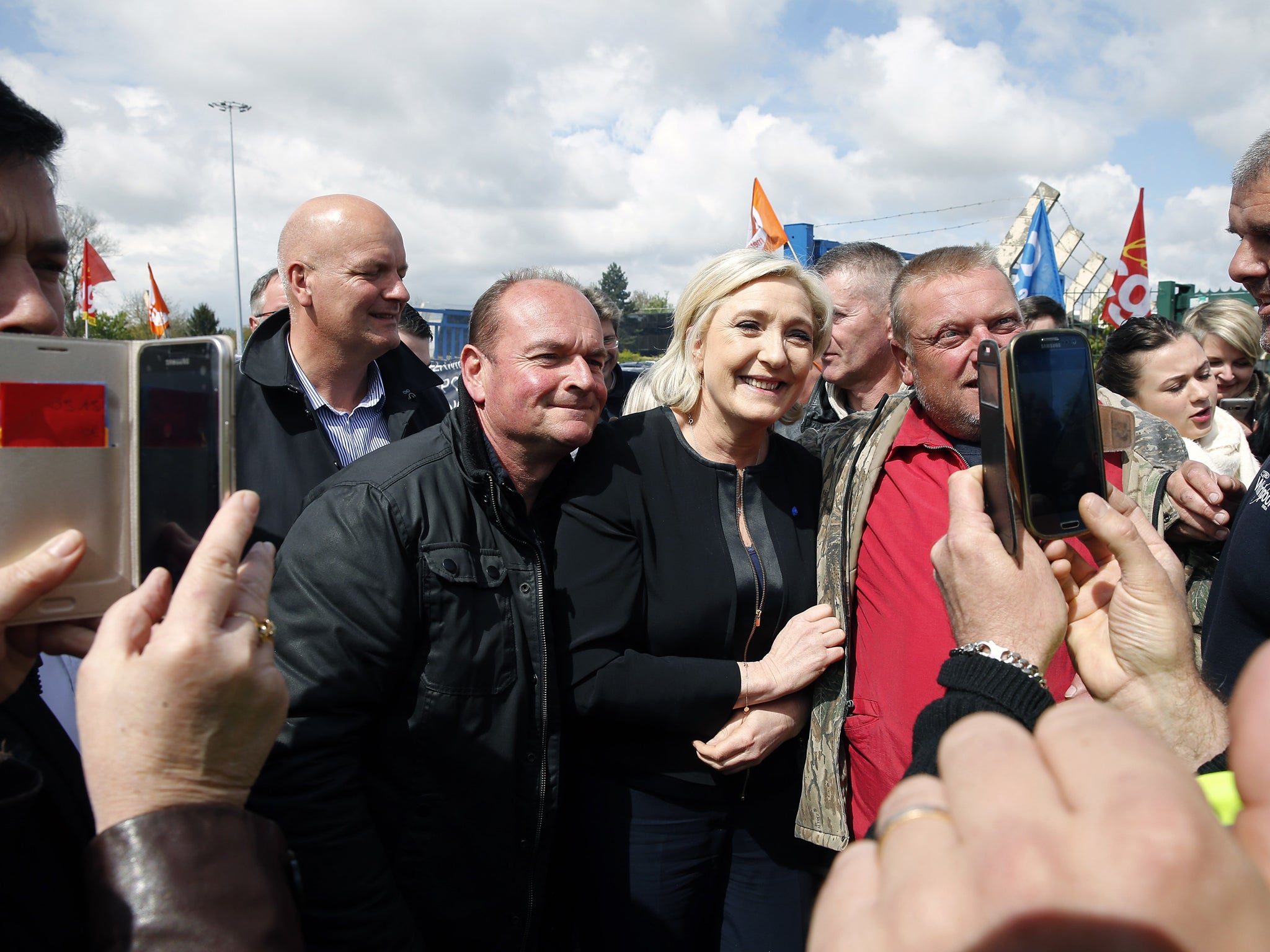 French far-right Front National (FN) presidential election candidate, Marine Le Pen, poses for selfies with strike employees of Whirlpool, in Amiens, France (Chesnot/Getty)