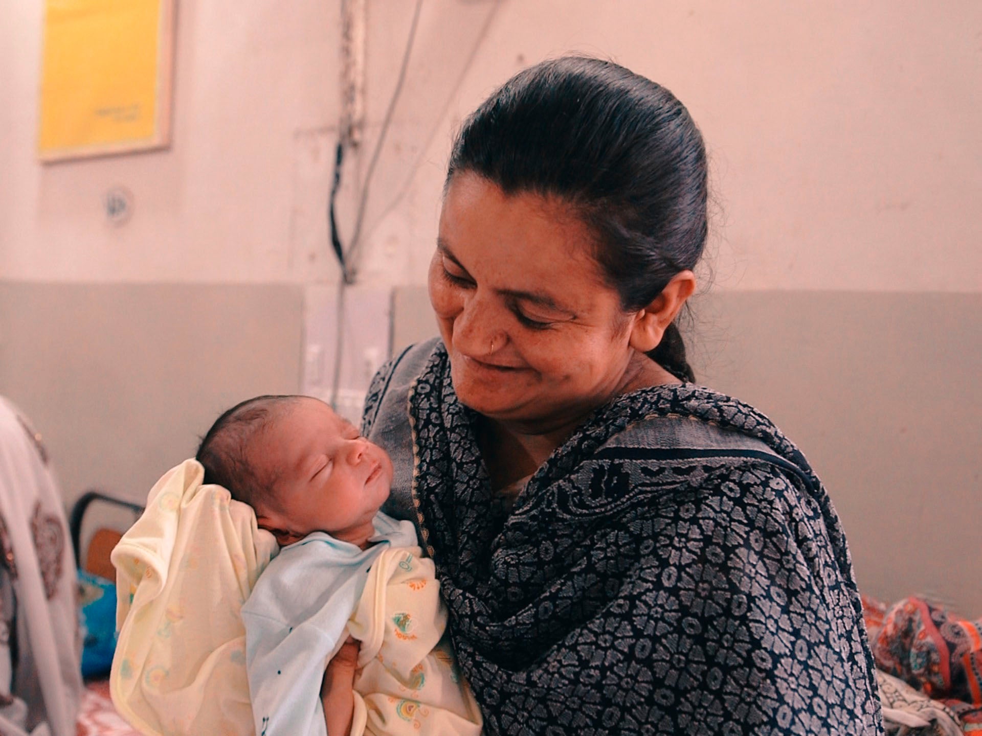 A doctor holds a baby born during the trial of the drug in Pakistan