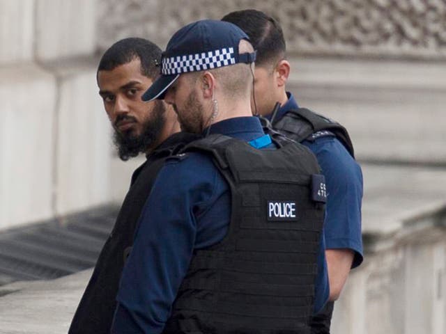 A man is led away by police during a security incident in Whitehall