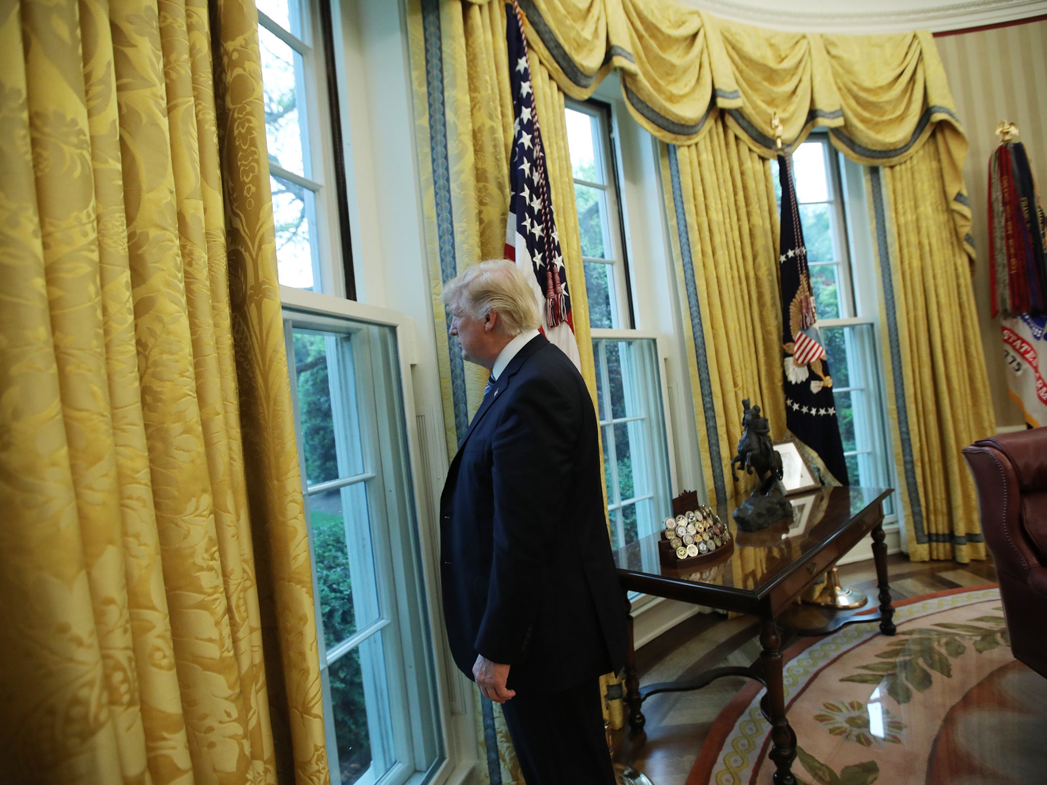 President Donald Trump looks out of a window in the Oval Office
