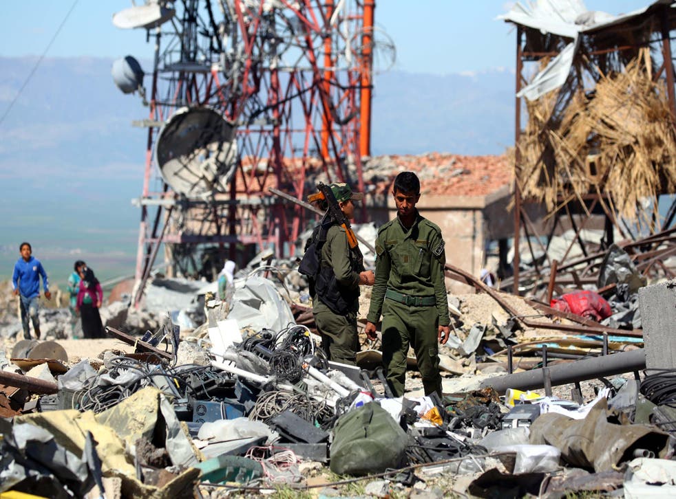 The aftermath of a Turkish airstrike is inspected by members of the Kurdish People's Protection Units (YPG), seen by the United States as a key ally in the fight against Isis