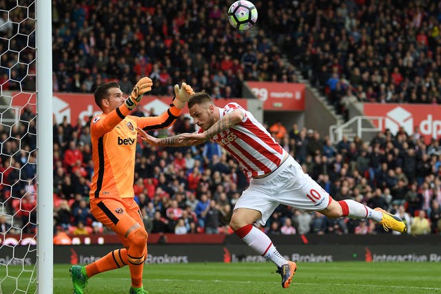 Adrian punches the ball clear under pressure from Marko Arnautovic