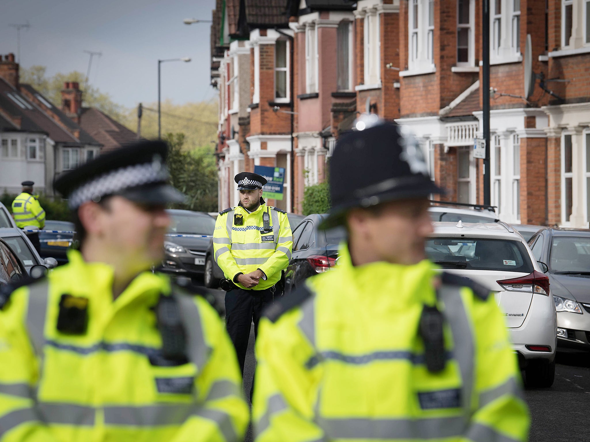 Police at the scene where a woman got shot by armed police in Harlesden Road, London.