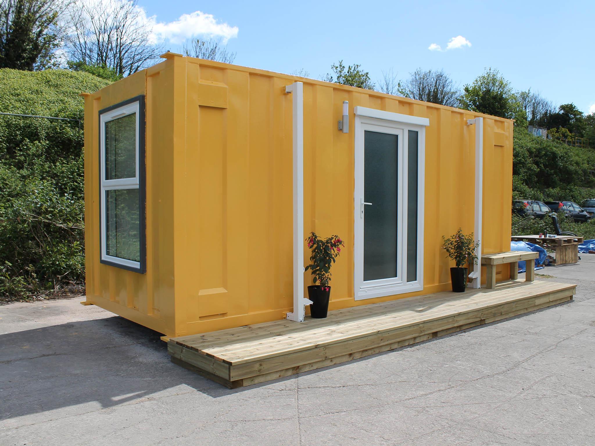 The final touches are put on the first shipping container, which is decked out with a bed, wardrobe, toilet and shower