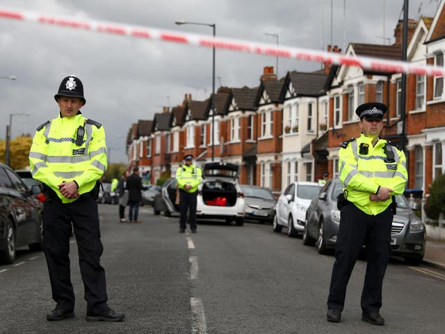 Police officers stand next to terraced housing in Harlesden Road.. British counter-terrorism police said on Friday they had thwarted an active plot after a woman was shot during an armed raid on a house in north London in the second major security operation in the British capital in the space of a few hours